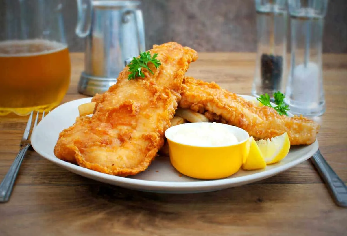 Fish and chips on a plate with tartare sauce. 