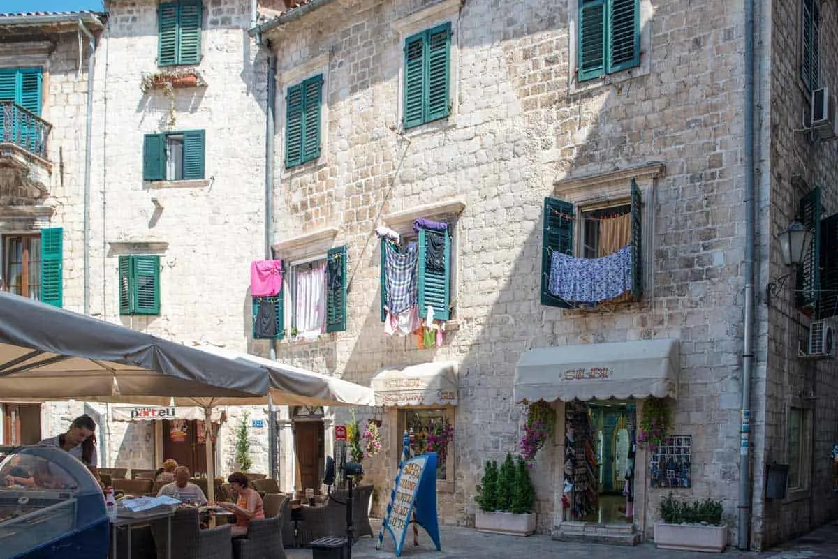 Old Town Kotor with typical restaurants and washing hanging from windows.