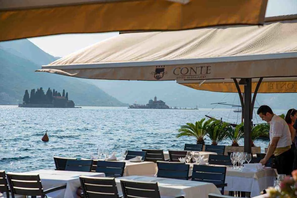 Waterside restaurant in Perast with Our Lady of the Rocks island in the background.