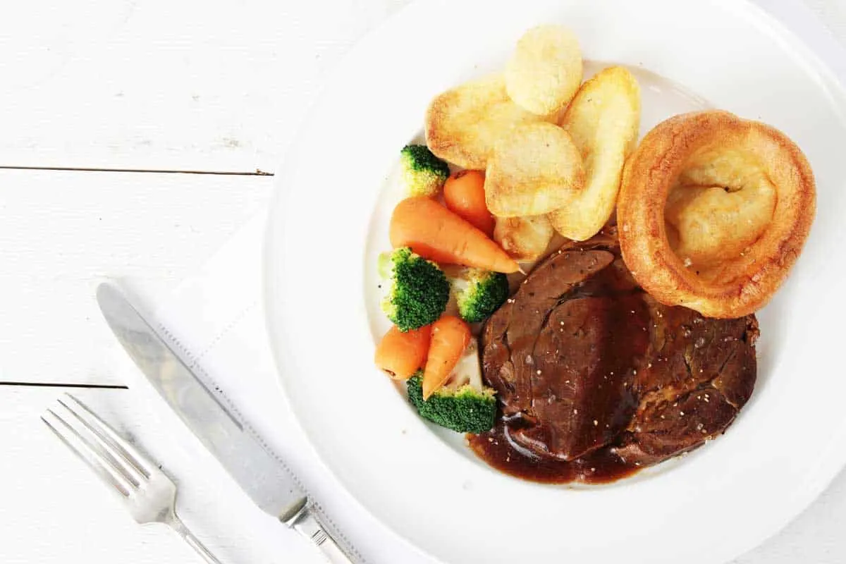 Typical roast beef dinner with vegetables and Yorkshire puddings. 