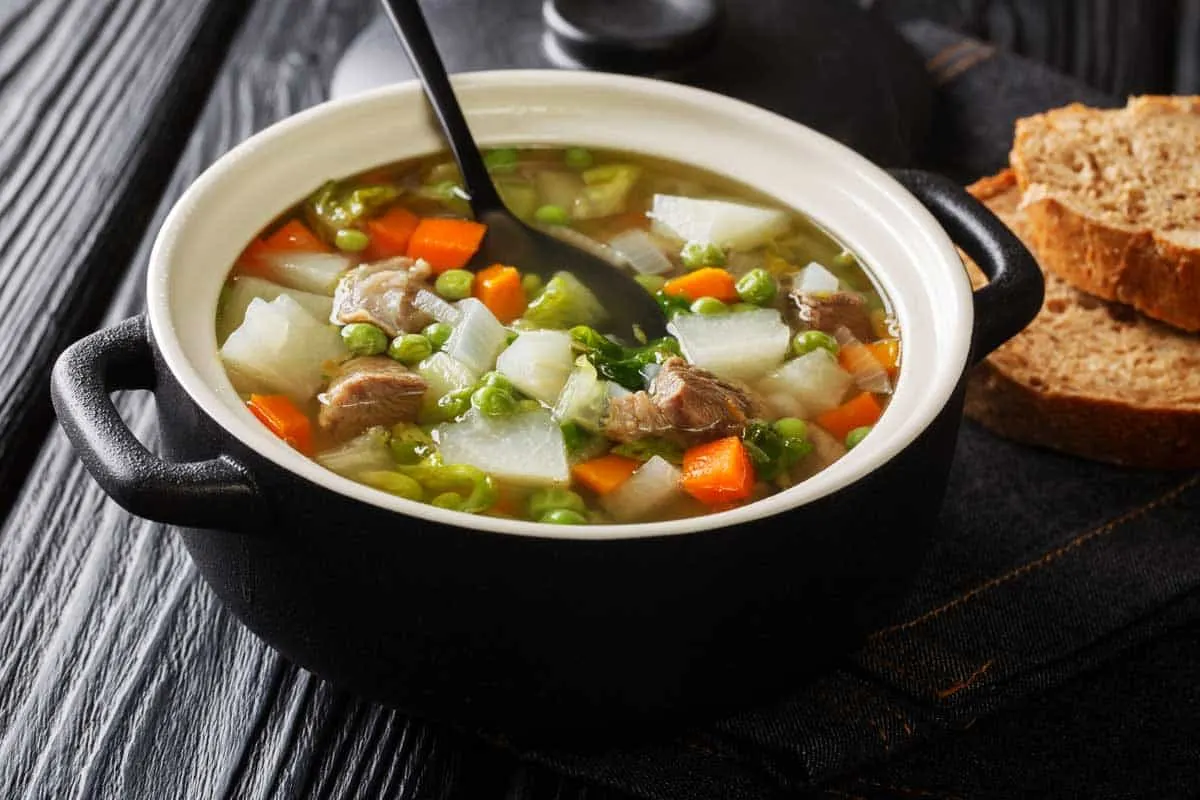 Bowl of hearty Welsh Cawl soup with bread. 