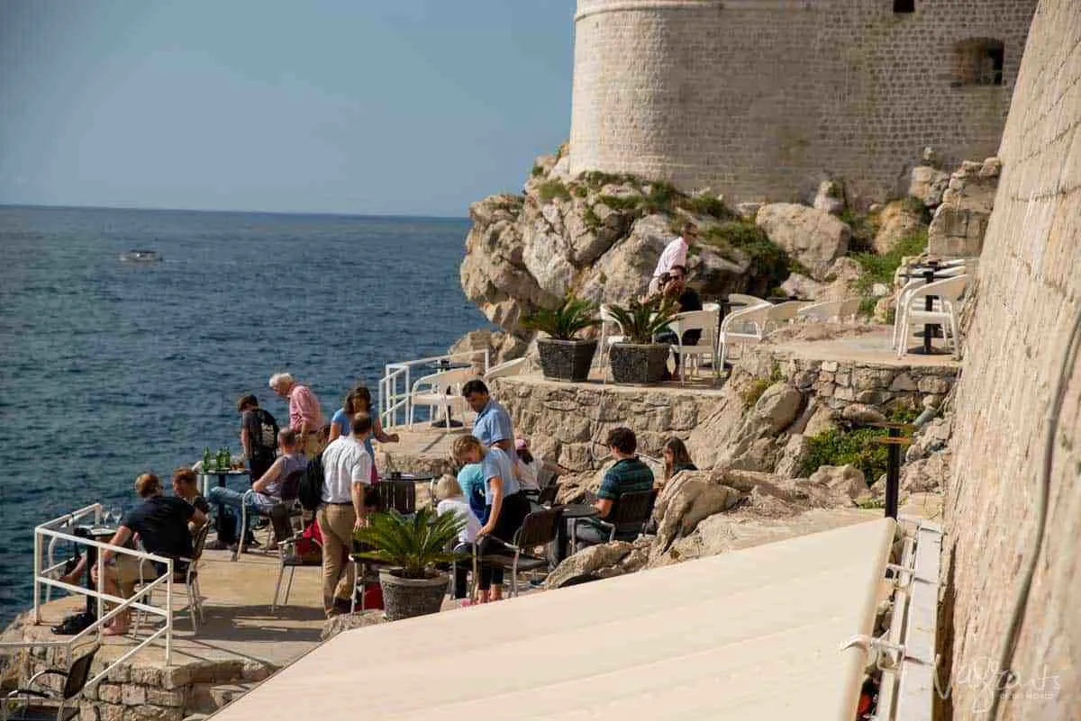 People waiting for sunset over the Adriatic on the cliffside bar outside the walls of Dubrovnik Old Town.