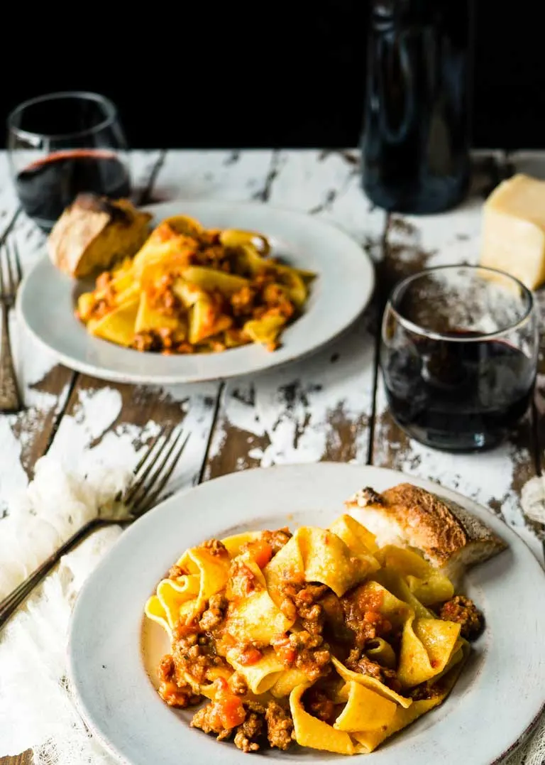 Plates of paparadelle pasta with bolognese sauce. 