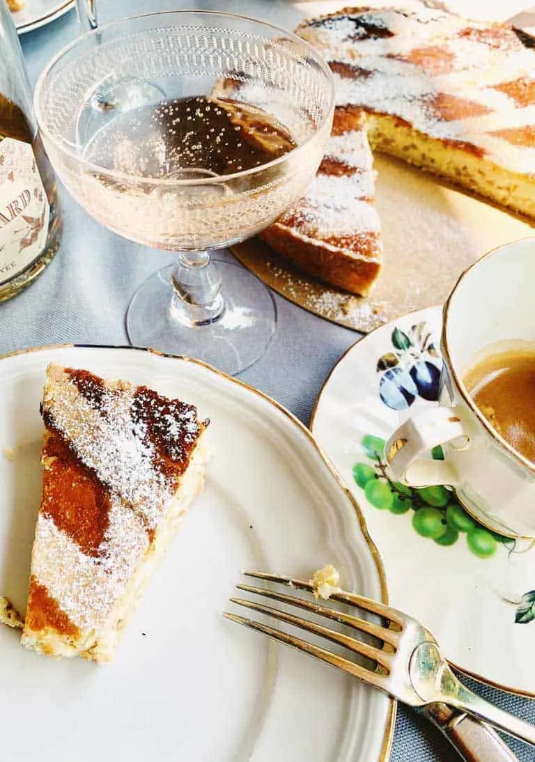 Slice of cake on fine china plate with old fashion champagne glass. 