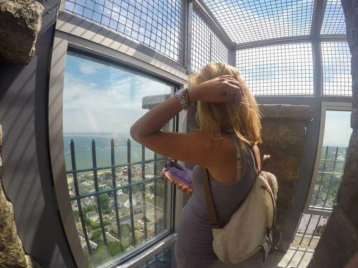Young woman admiring the views from the top of the Pilgrim Monument in Cape Cod. 