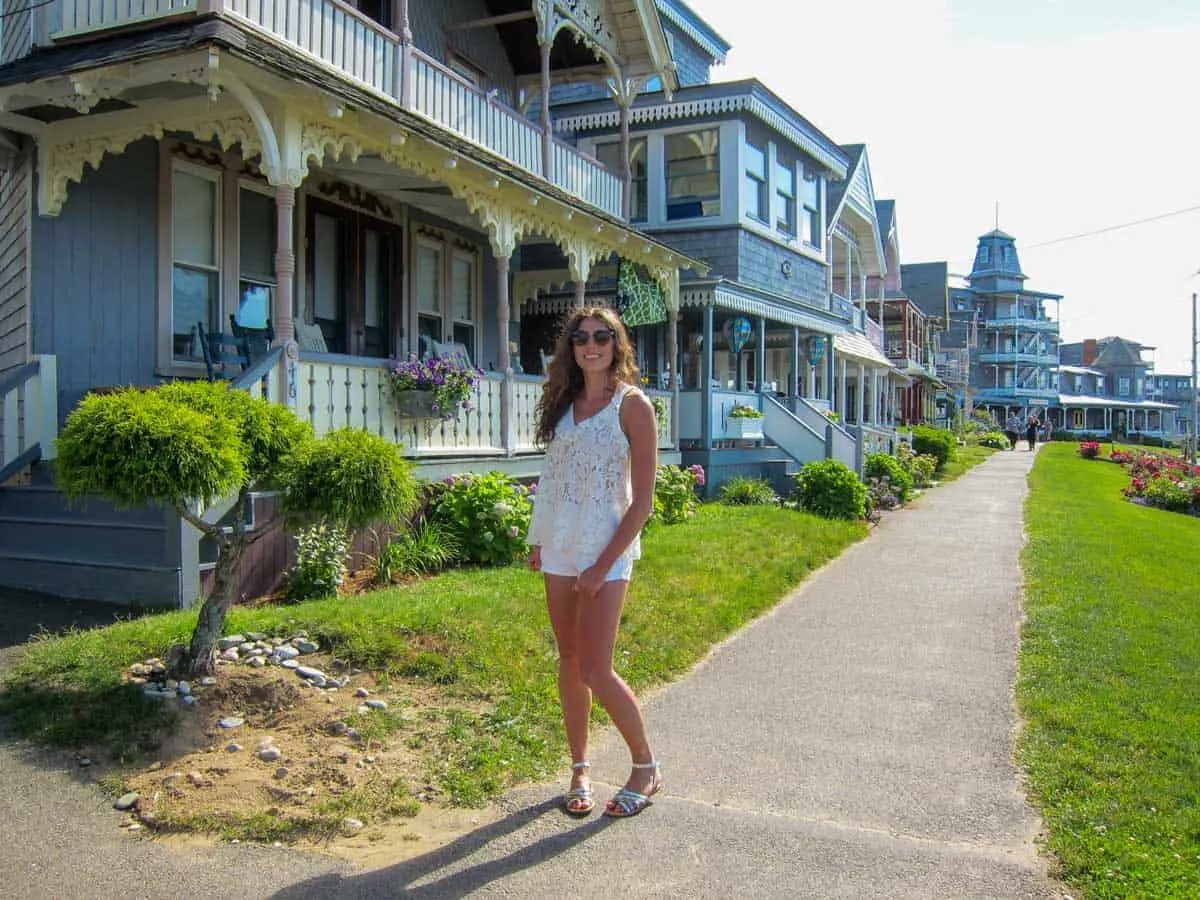 Young girl posing on the sidewalk in front of the Gingerbread houses of Martha's Vineyard. 