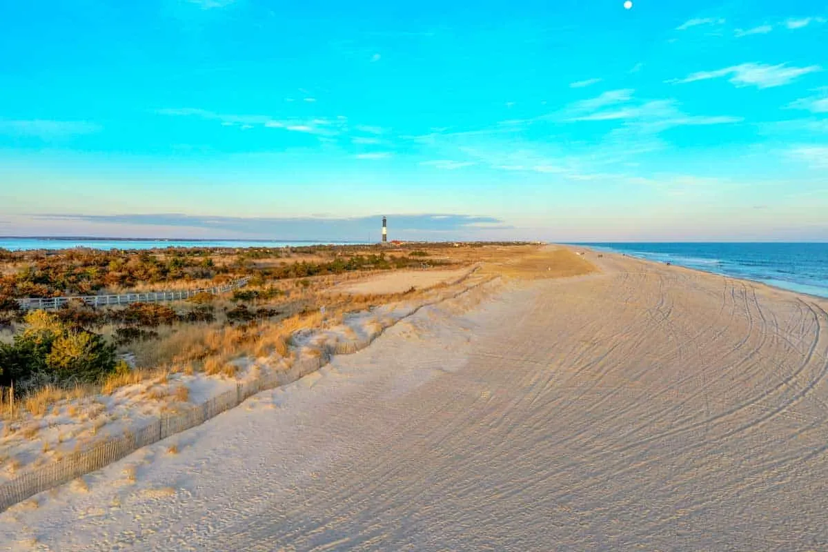 Views along sandy beach on Fire island with the lighthouse in the distance.