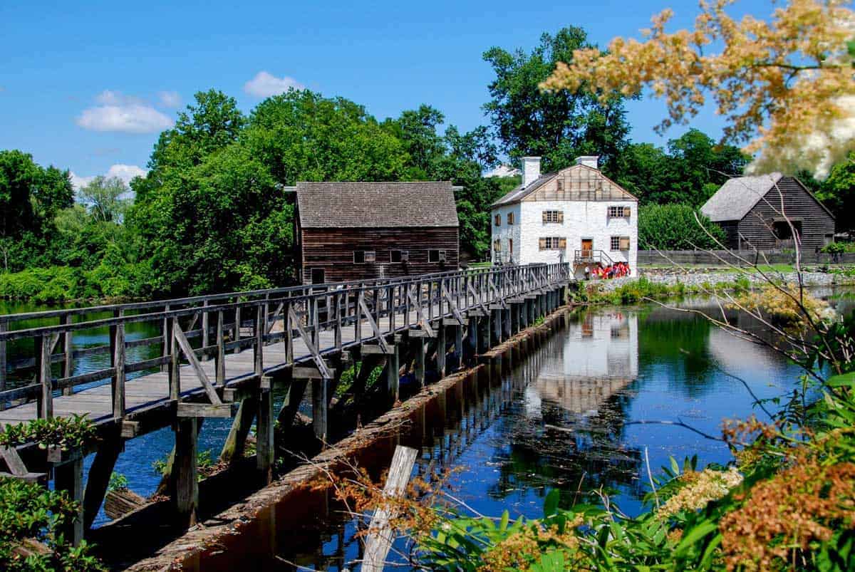 Old White millhouse at the end of a wooden bridge in Sleepy Hollow.