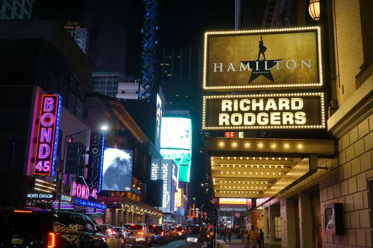 The theaters on Broadway lit up at night. 