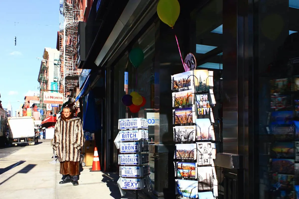 Man wearing a long fur coat in the streets of Little Italy New York