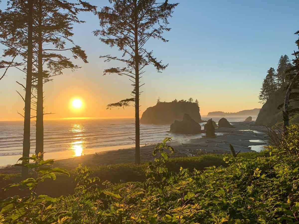 Sun setting over the beach with rugged coast line.