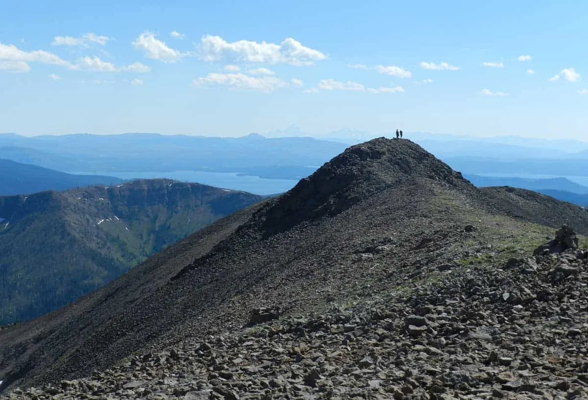Hikers on a summit peak in the distance on Avalanche hiking trail in Yellowstone NP.
