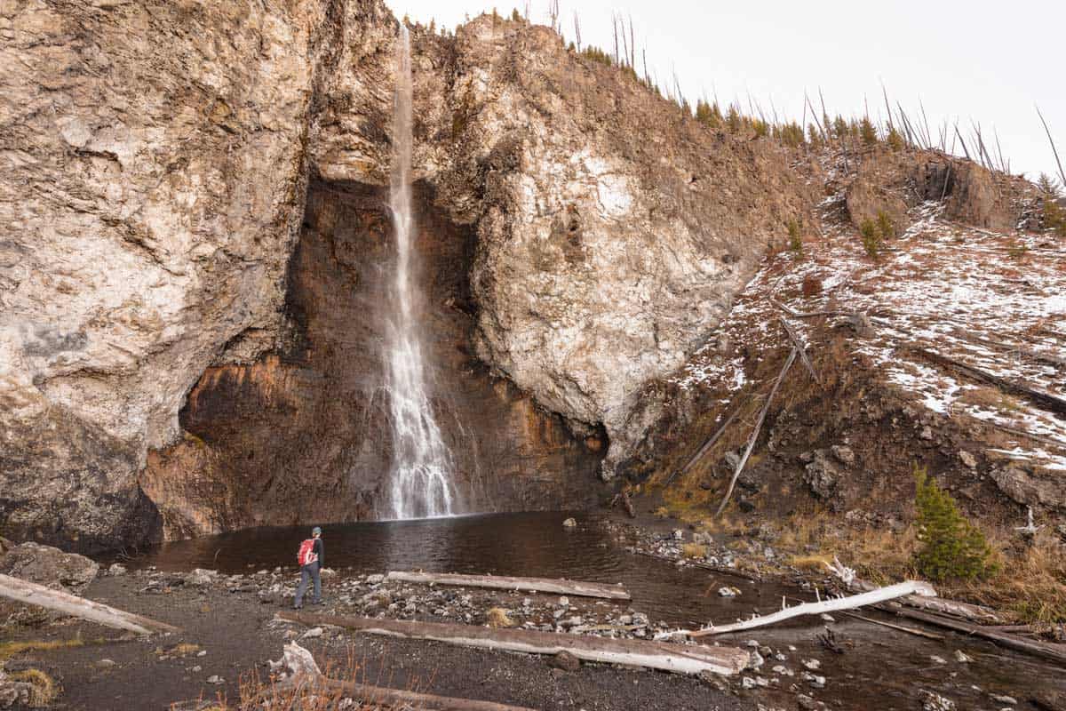 Hiker standing in front of Fairy Falls in Yellowstone.