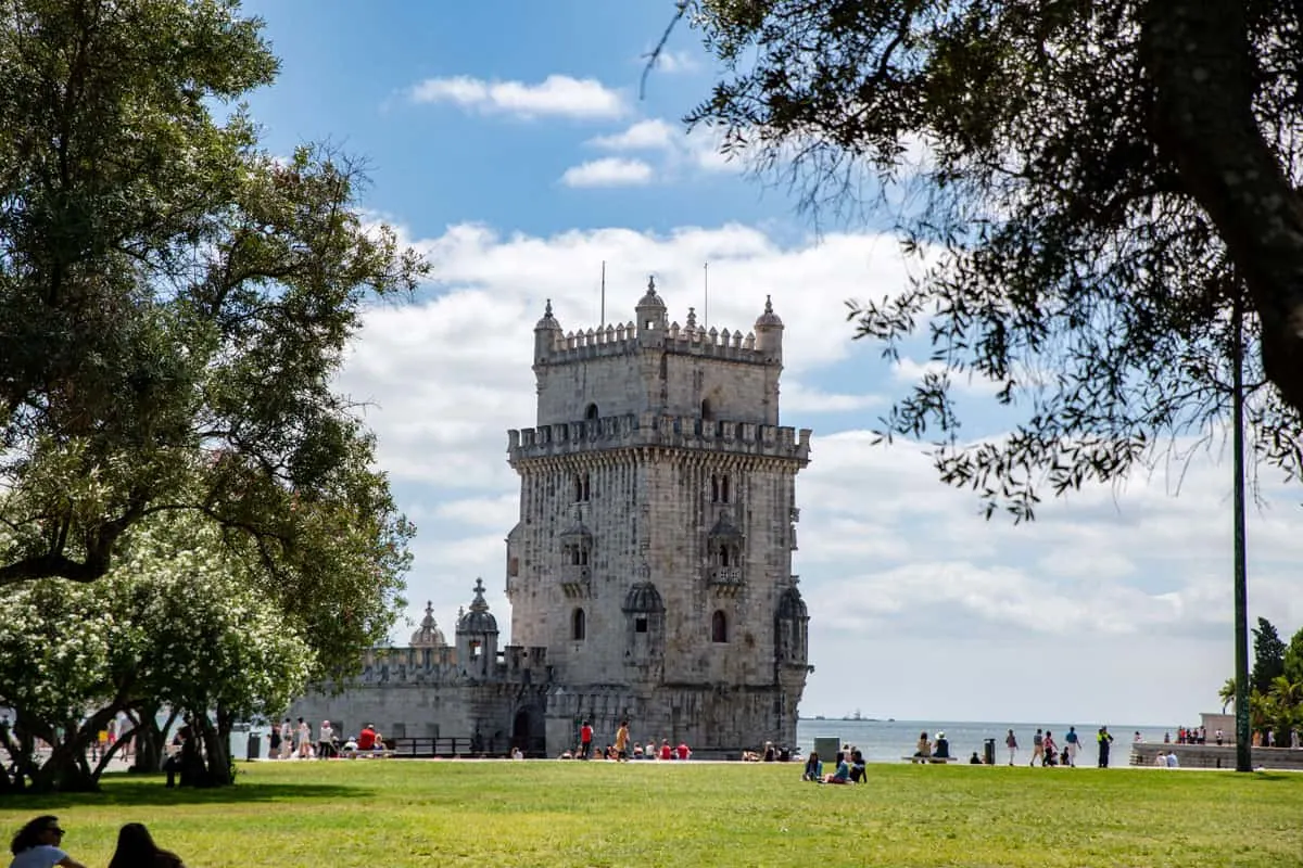 Tower of Belem in Lisbon with people enjoying the surrounding park.