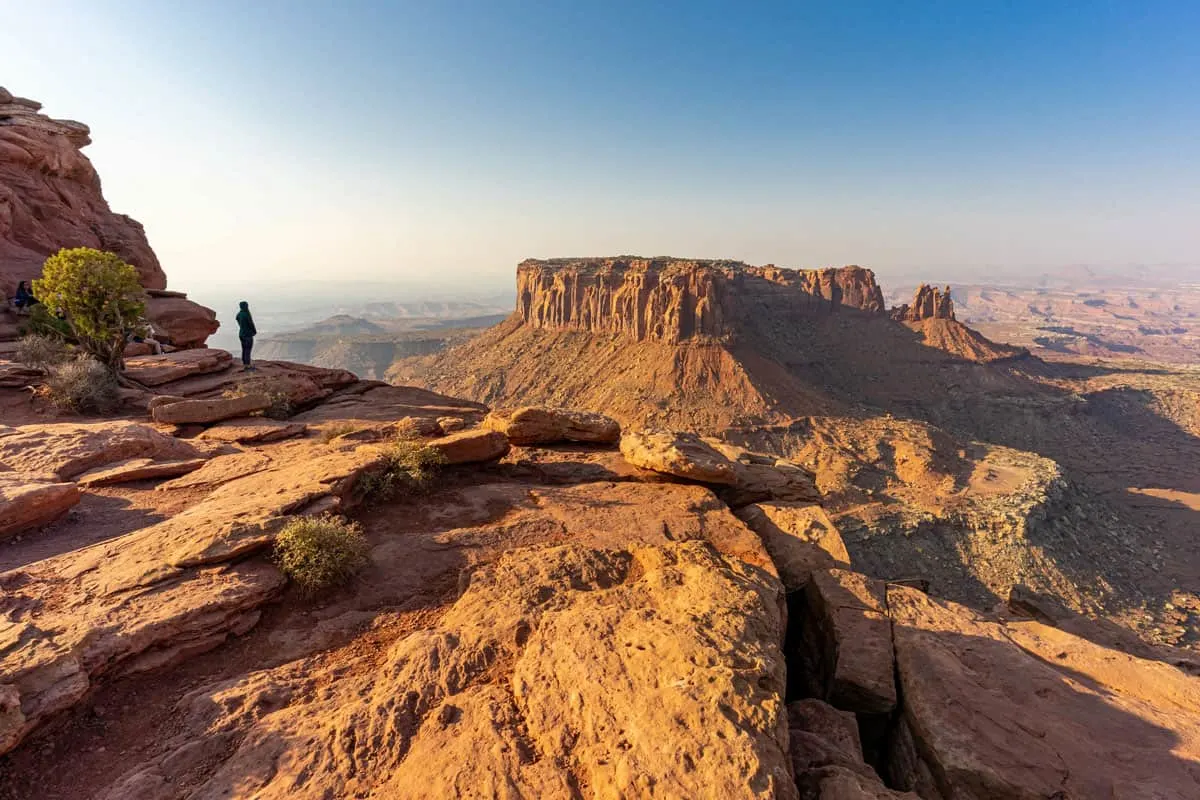 People standing on a cliff edge admiring the view in Moab Utah.