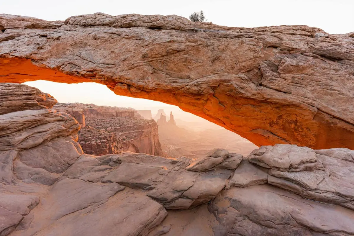 Sunrise through a red rock arch in Moab Utah.