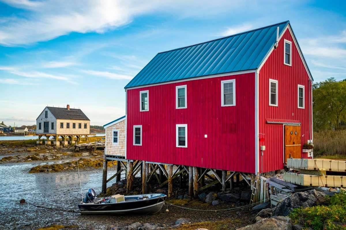 Brigh red fishing shacks over the water in Maine.