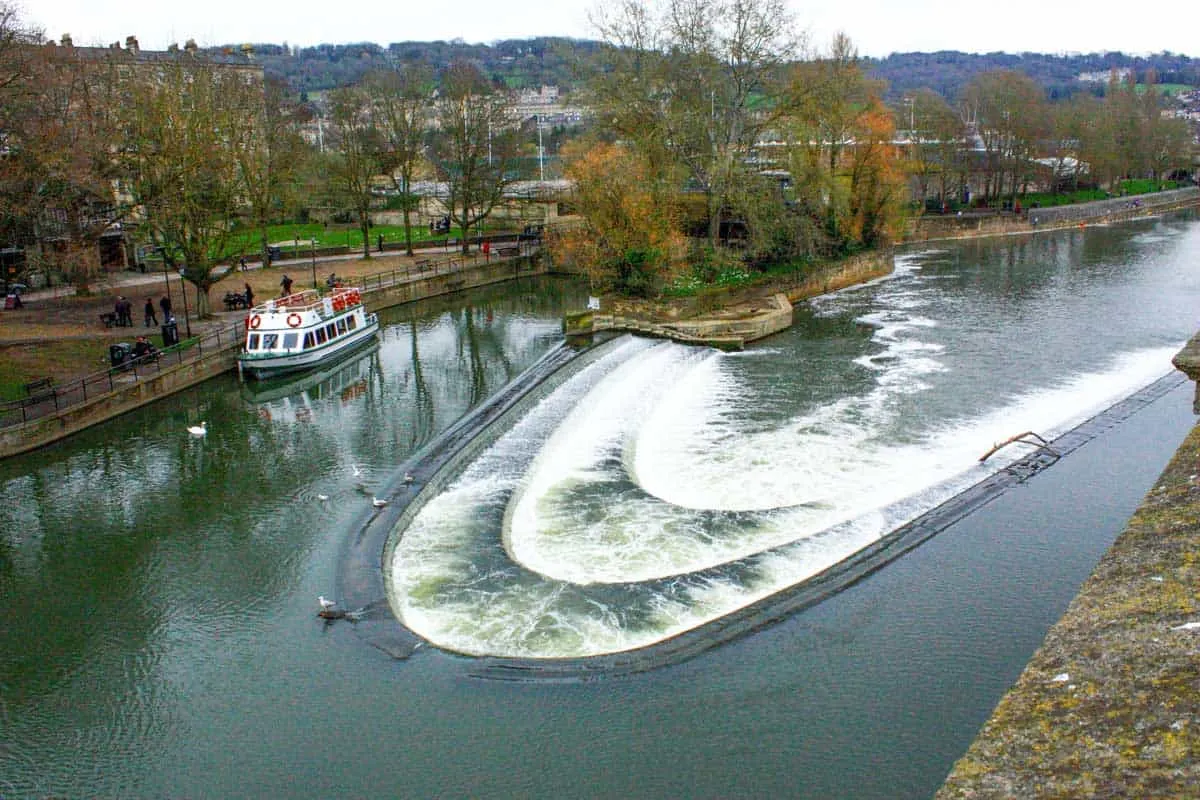 The Bath weir with a boat moored to the side.