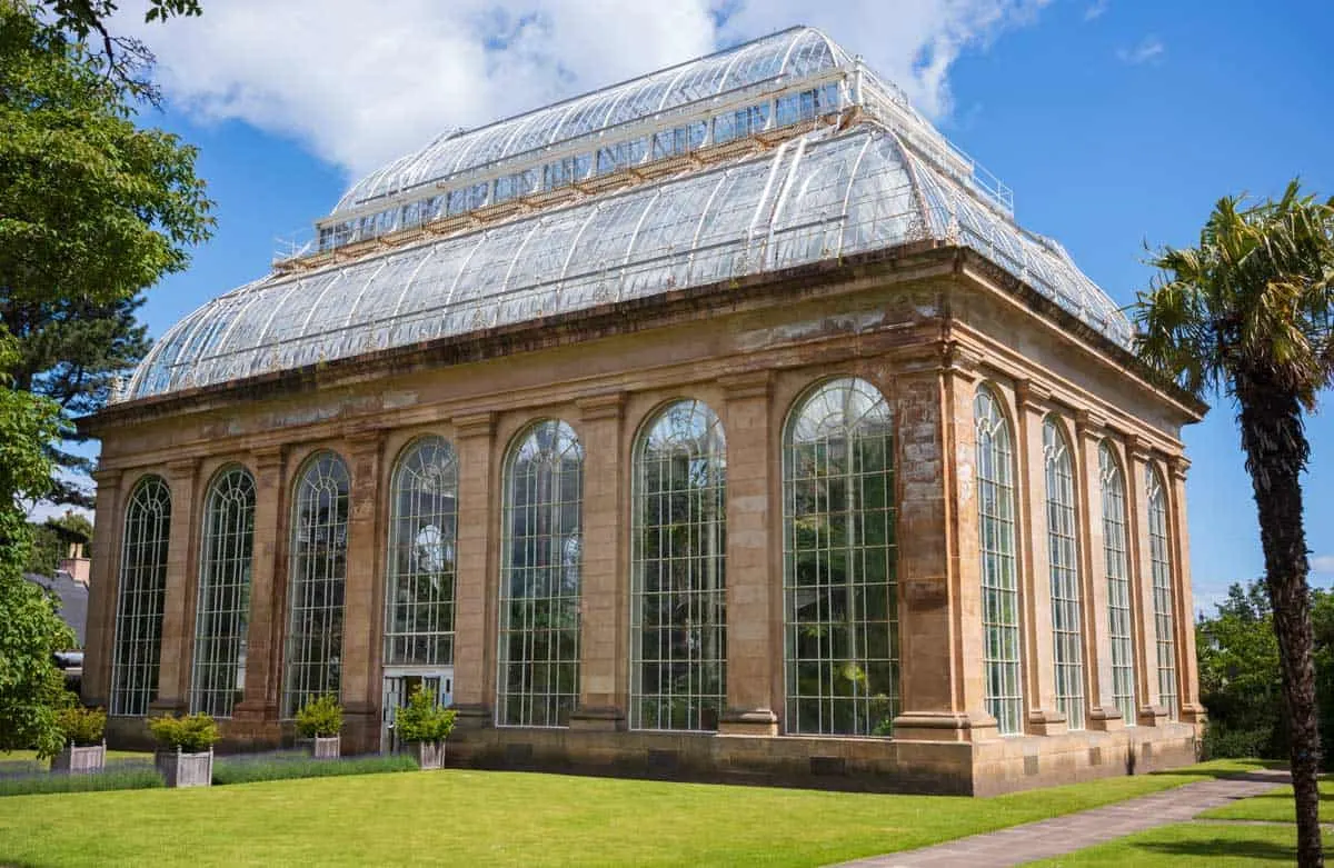 The Palm House on the Edinburgh Royal Botanic Gardens on a sunny day.