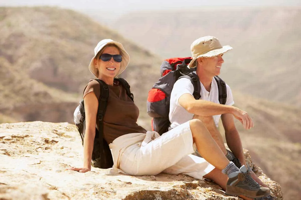 Young hiking couple resting on a rock outcrop in Spain.