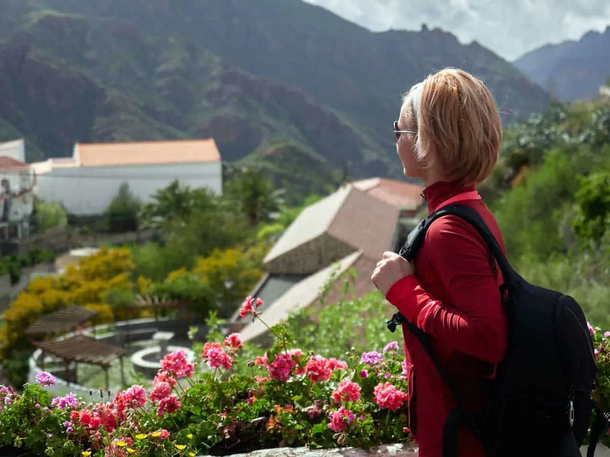 Female hiker looking over a mountain village in Spain on a walking holiday.