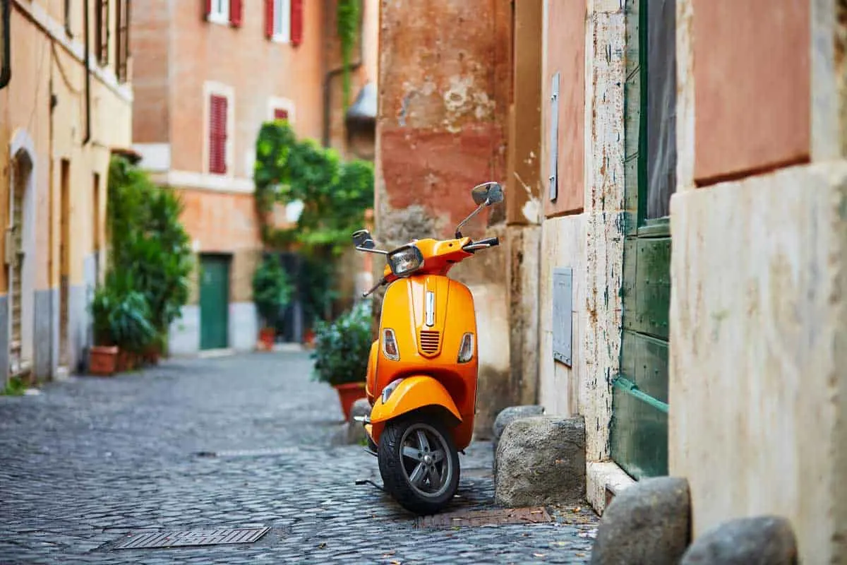 A classic Vespa scooter in the cobble streets of Trastevere in Rome. 