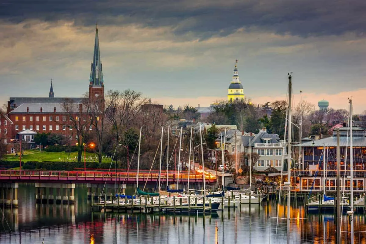 Historic city Annapolis skyline at sunset with yachts moored on the water.