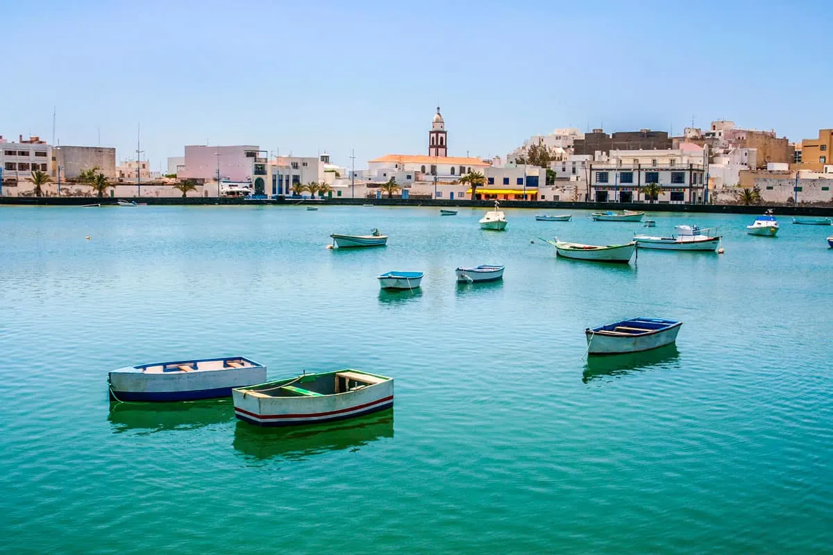 Row boats moored on turquoise water in Charco de San Gines Lanzarote island.