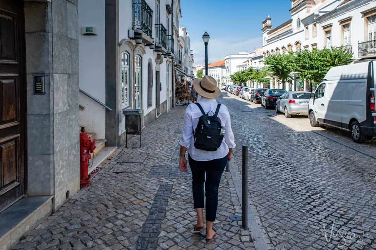 A woman walking down the quaint streets of Old Town Tavira in Portugal. 