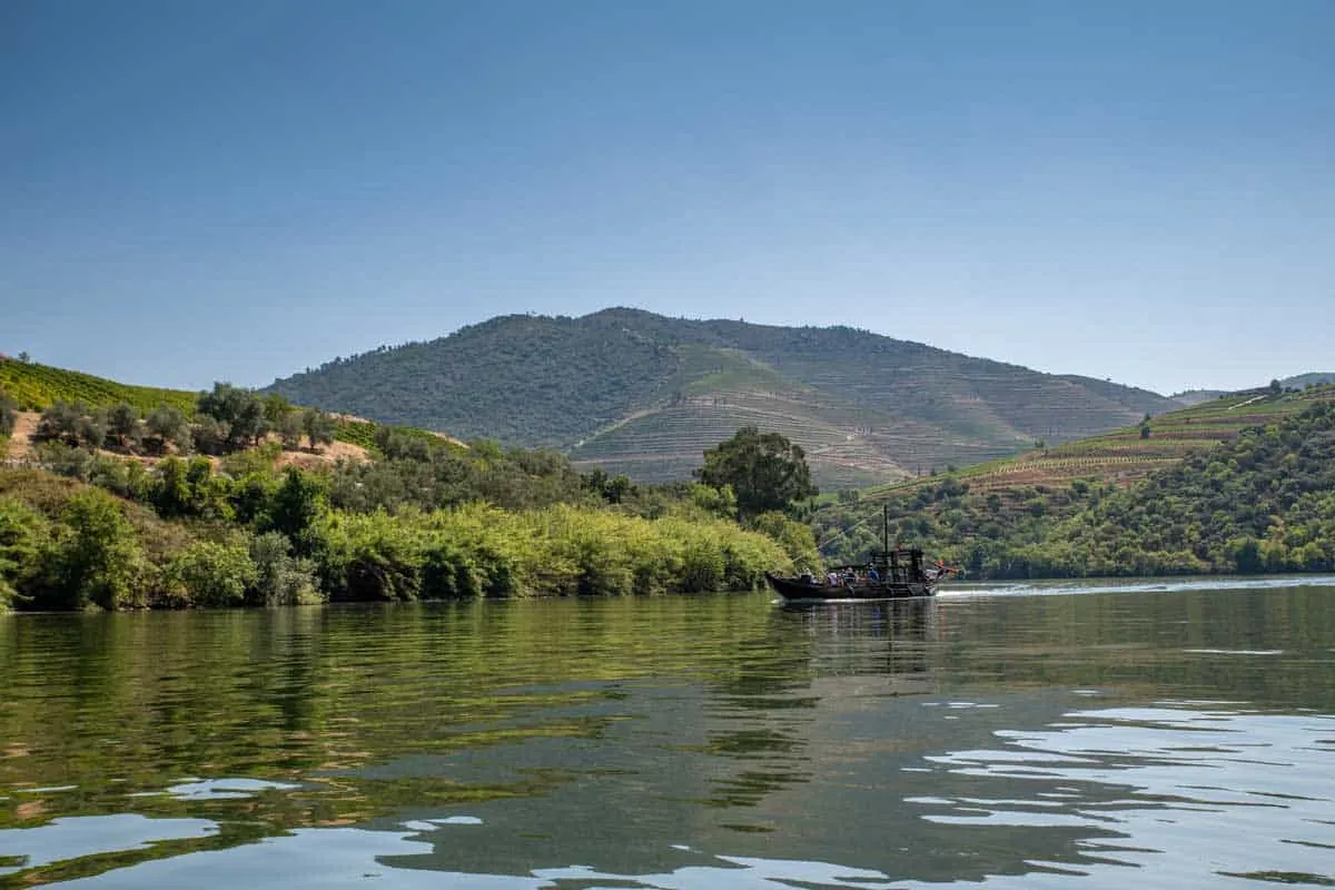 A traditional Rabelo boat cruising down the Douro river in Portugal.  