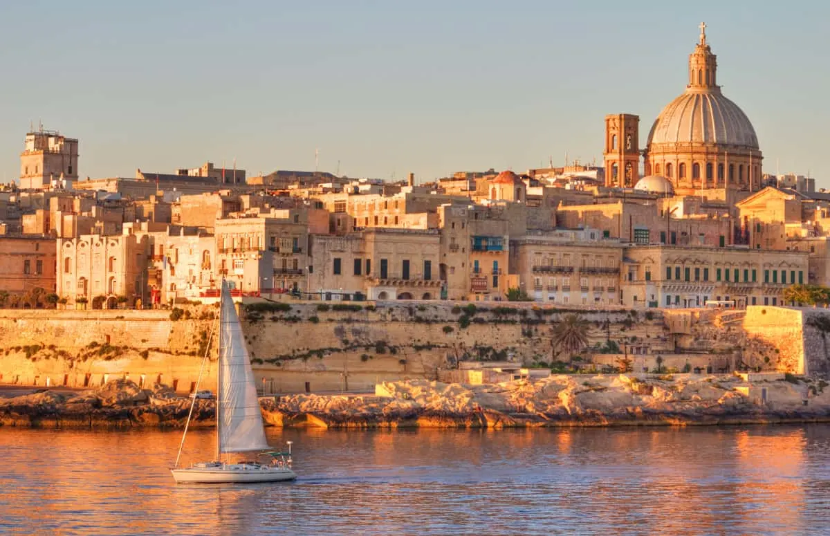 Saling boat travelling past the ancient city of Valletta in Malta.