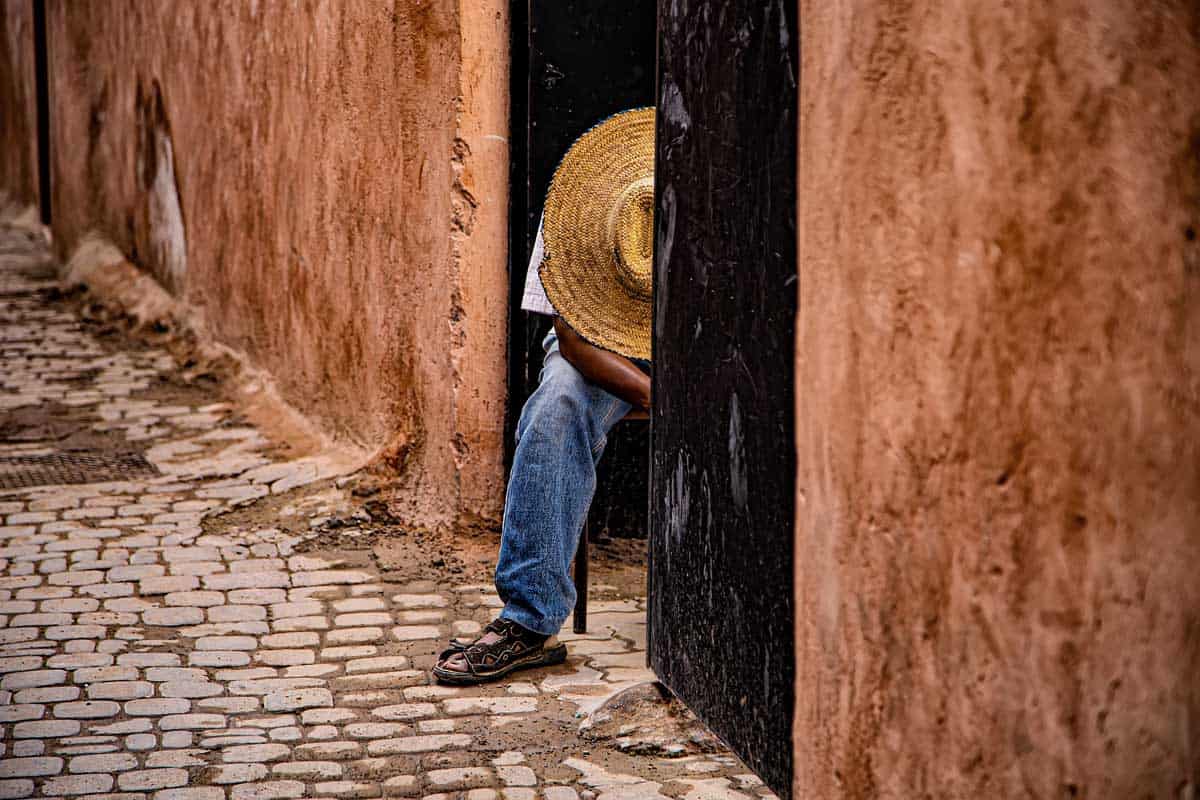 Man sleeping in a large straw hat in Marrakech Medina.
