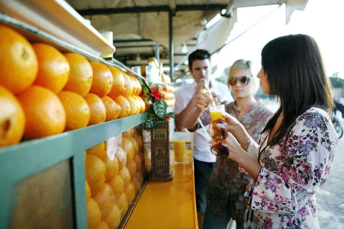 Young people drinking orange juice from a vendor in marrakech.