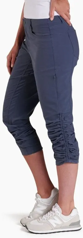 Woman waist down modelling a pair of blue convertible travel pants for trekking.