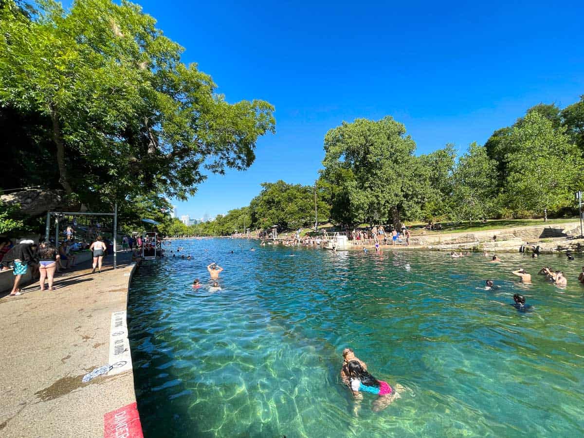 People swimming in the clear waters of Barton Springs in Austin Texas. 