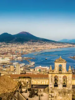 View over the city of Naples and the harbour at sunset. Mt Vesuvius sits in the background.