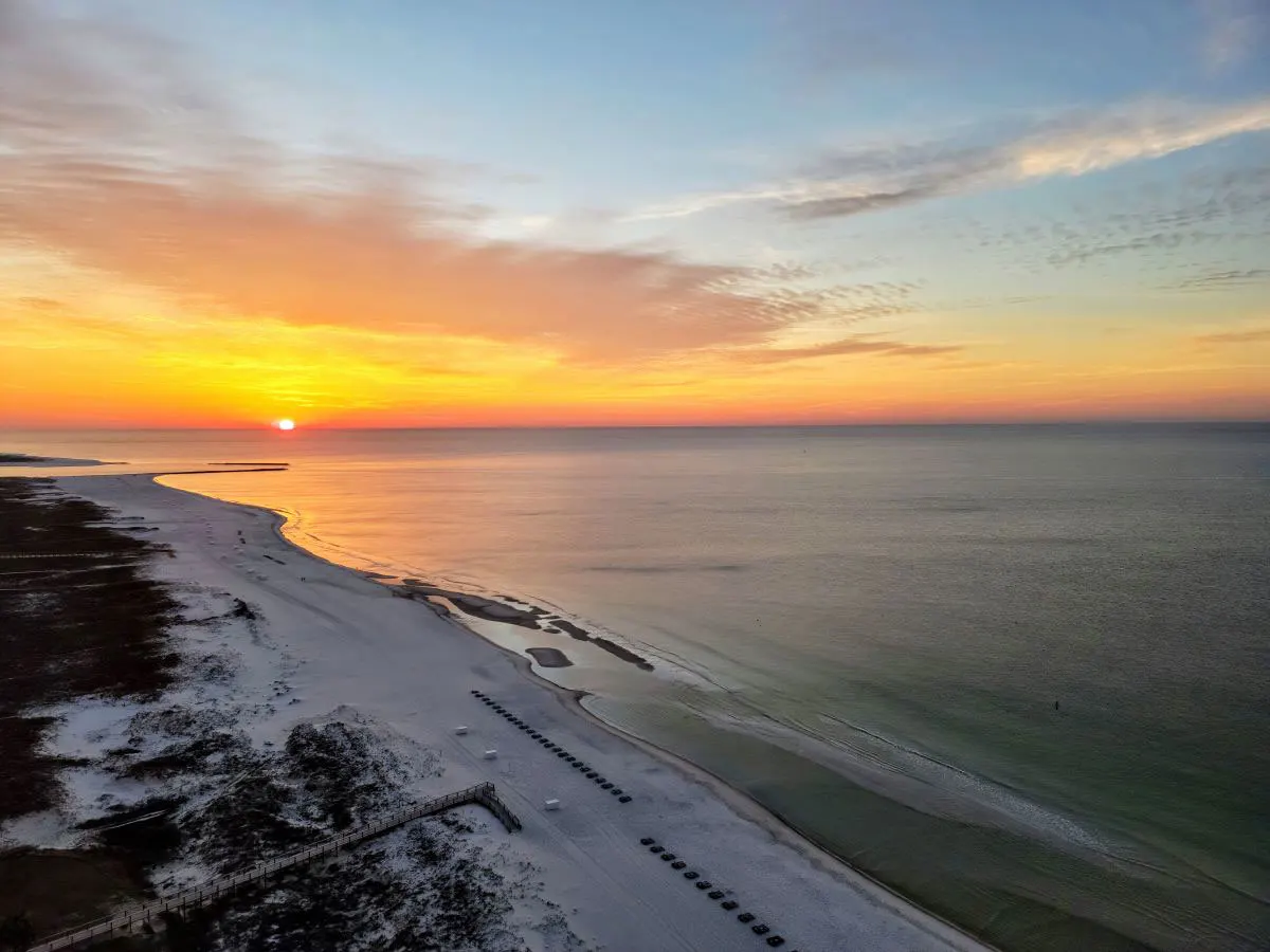 Aerial view of sunset over a white stretch of beach in Gulf Shores Alabama. 