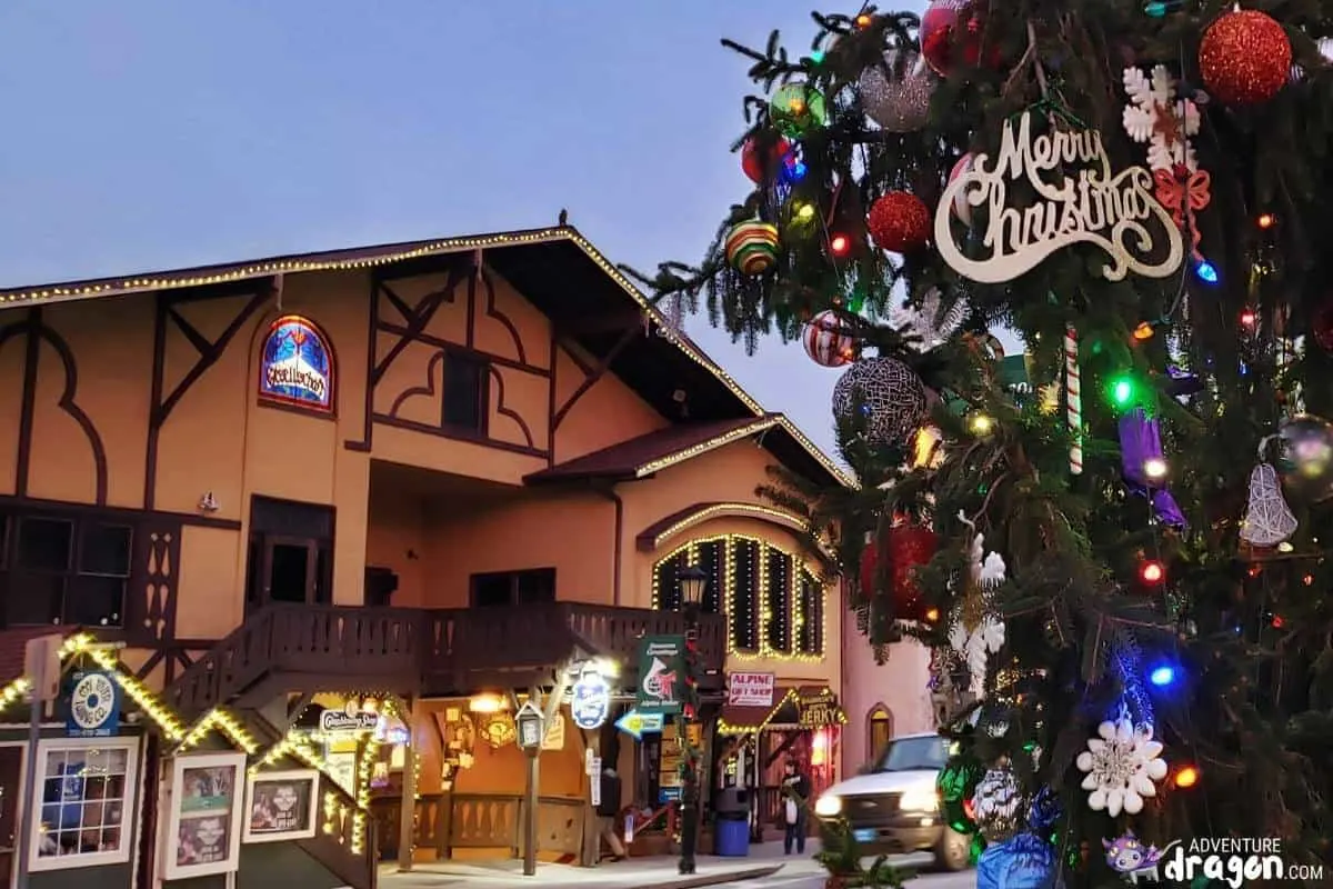 A large Christmas tree in front of a Bavarian style building wityh decorations in the main street of Helen Georgia.