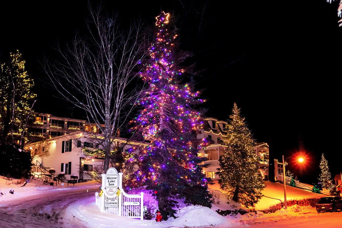Trees decortaed in Christmas lights outside the Mirror lake Inn in Lake Placid on a snowy night. 