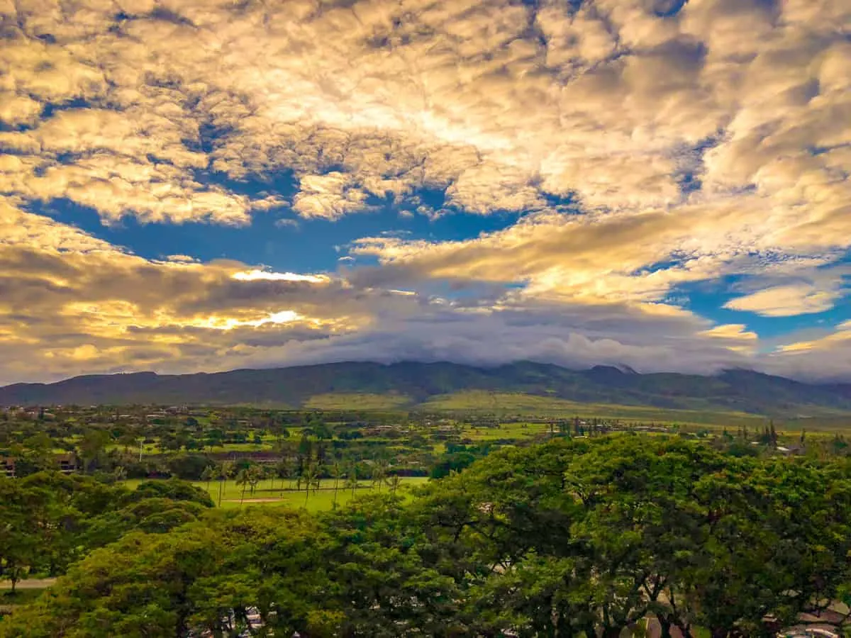 Sunset on a cloudy day over lush green field's in Maui Hawaii. 