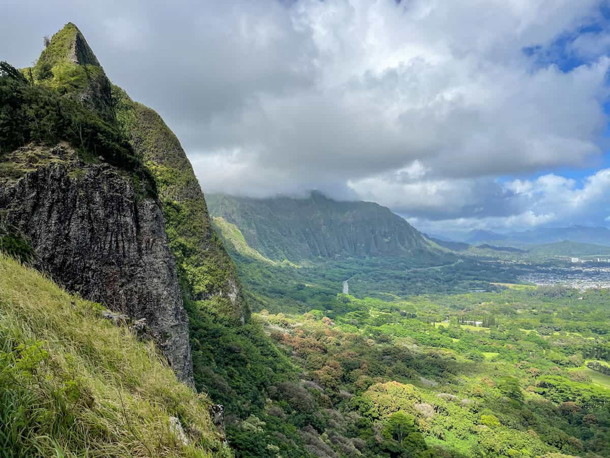 Lush green valley and mountains with dramatic grey skies on Oahu Hawaii. 