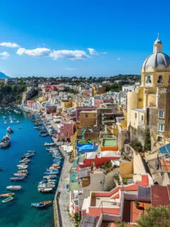 Aerial view of the colourful buildings and blue harbour on the Italian island of Procida near Naples.