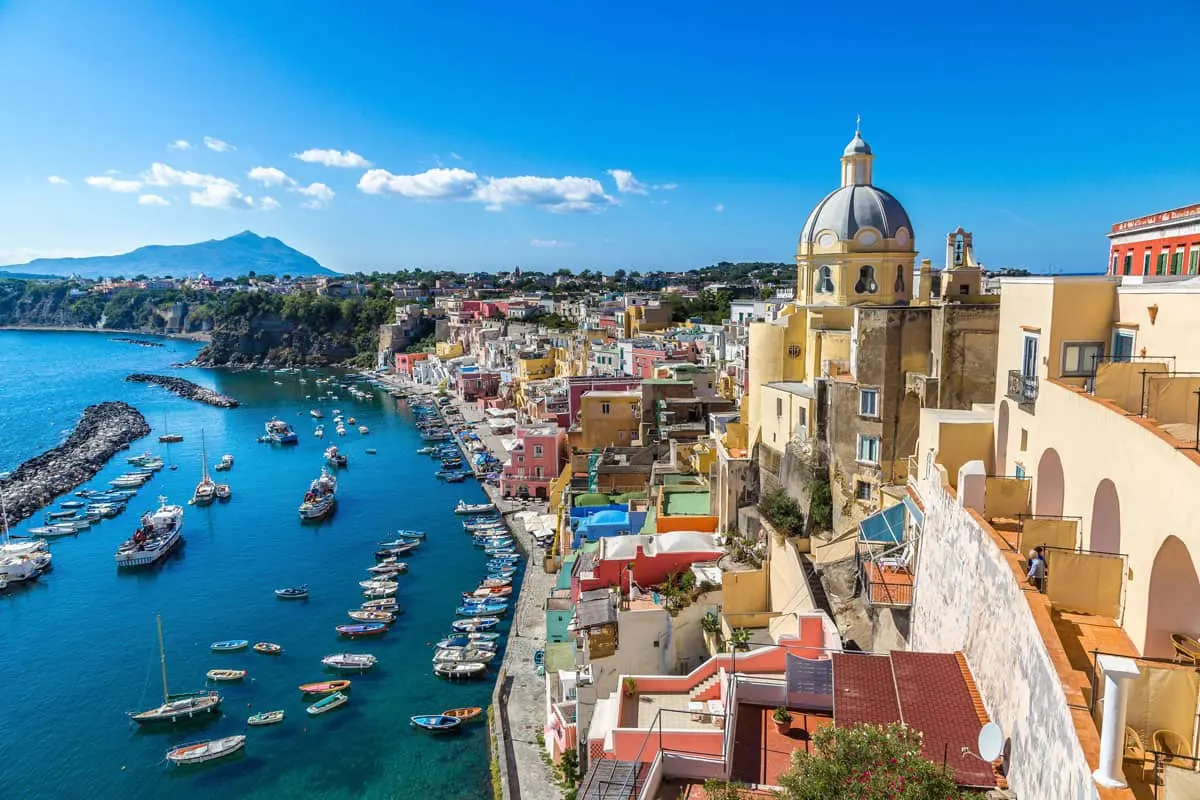 Aerial view of the colourful buildings and blue harbour on the Italian island of Procida near Naples.