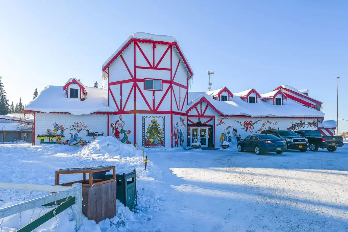 Red and white Christmas house covered in snow on a sunny day in North Pole Alaska. 