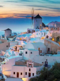 The typical white buildings of Santorini lit up at night.