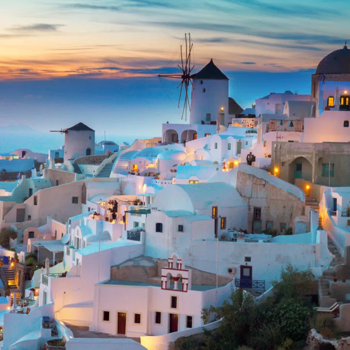 The typical white buildings of Santorini lit up at night.