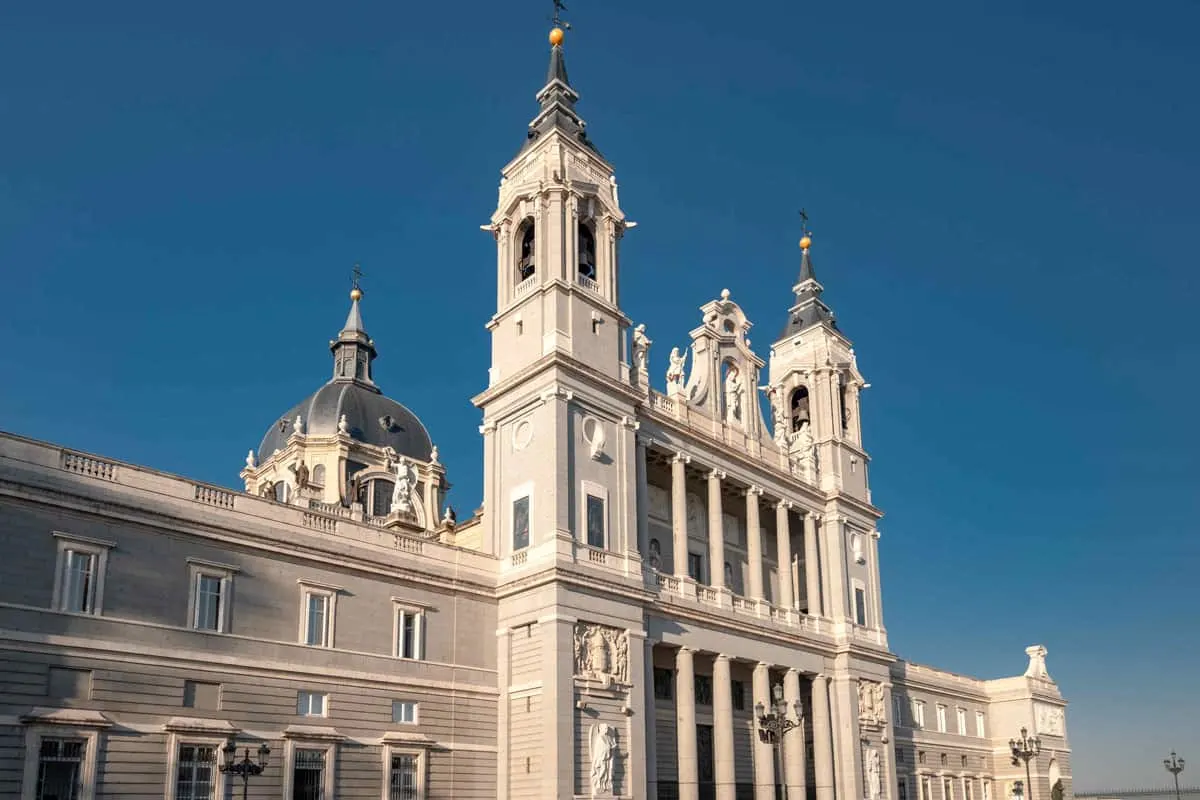 The facade of the Alamudena cathedral against a blue sky in Madrid. 
