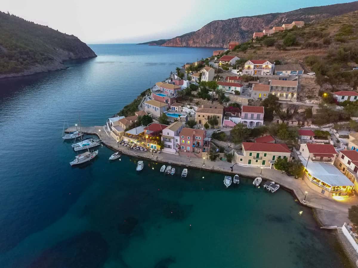 Aerial view of small colourful town of Assos on the waterfront at dusk.