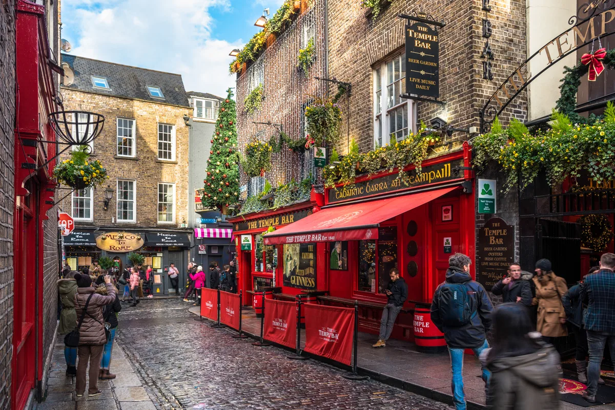 people standing in the cobble streets of the famous temple Bar district in Dublin. 