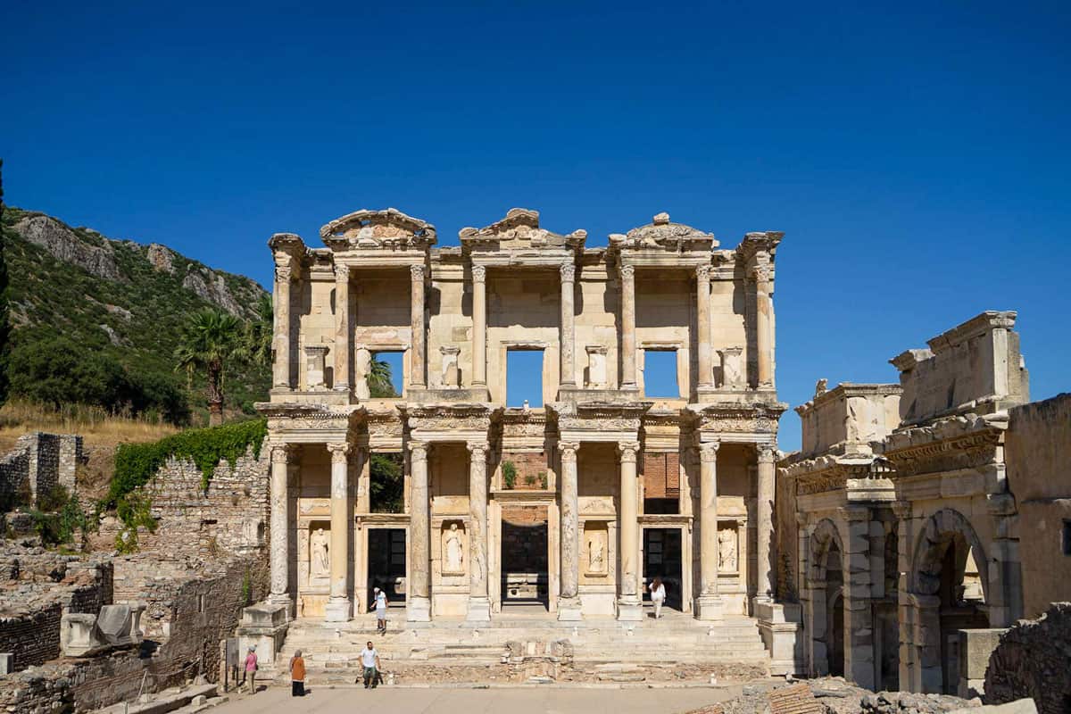 Tourists walking around the ancient city of Ephesus in Turkey on a clear day. 